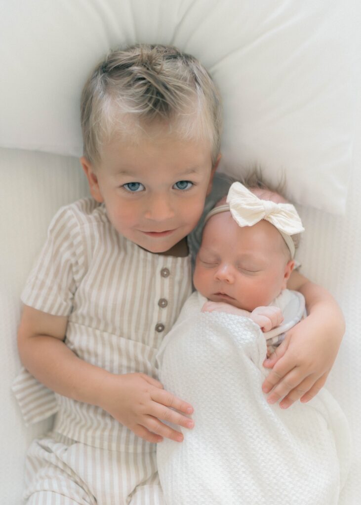 toddler holding newborn in at home newborn session in Salt Lake City utah. Captured by newborn photographer utah