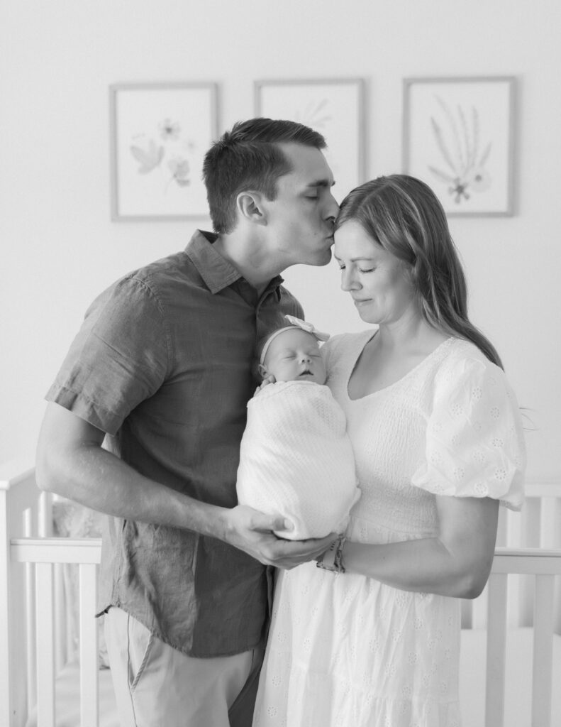 parents in the nursery with newborn captured by Salt Lake City family photographer. 