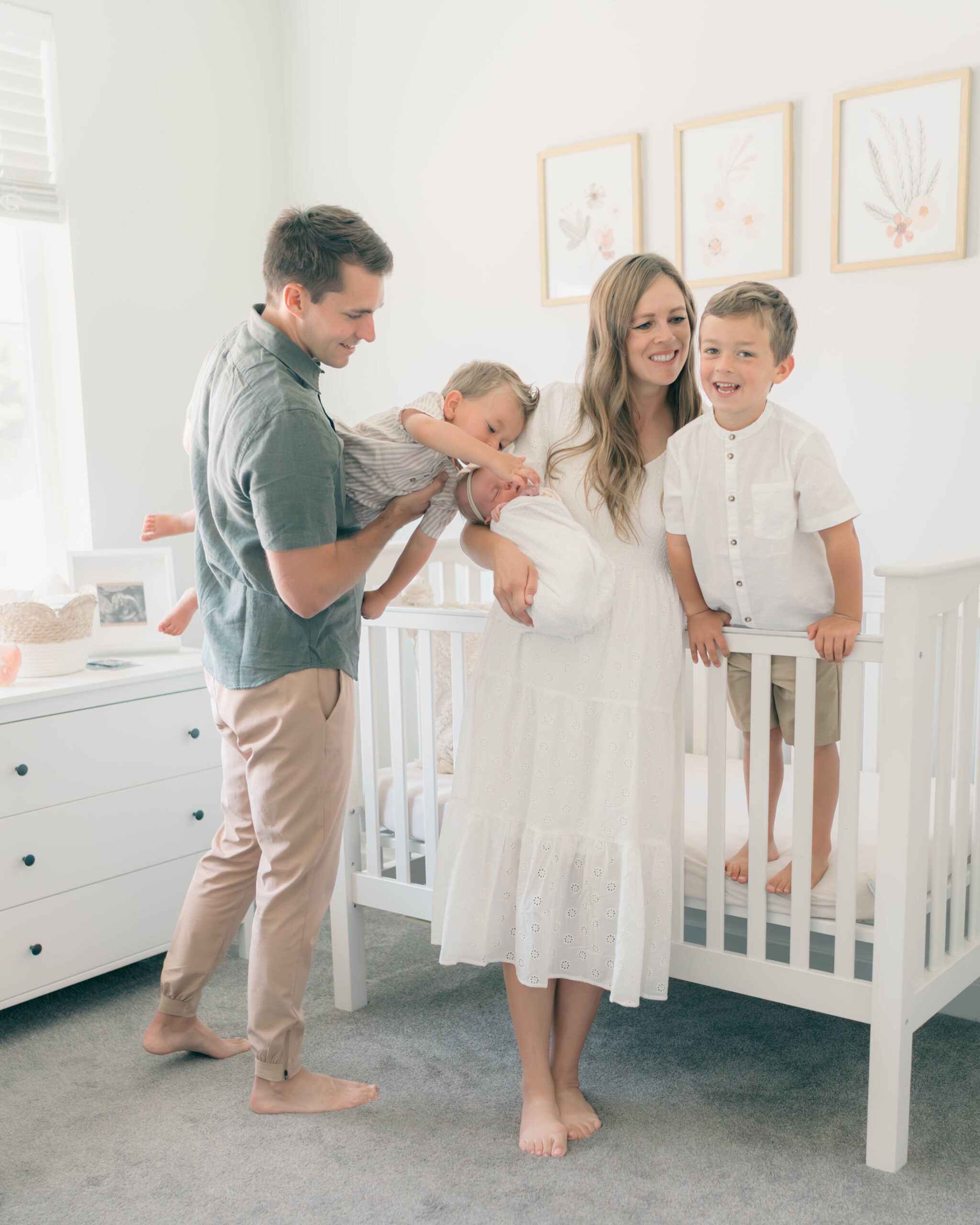 Family with newborn and toddlers in a bright, light-filled nursery during an in-home newborn session. Natural, playful, and connected moments captured by Utah newborn photographer