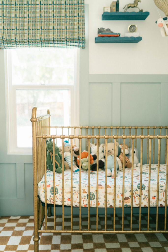 Vintage baby boy crib with stuffed animals by the window, bathed in natural light, in a charming nursery in Holladay, Utah. Photographed by Iris Graciela Photography