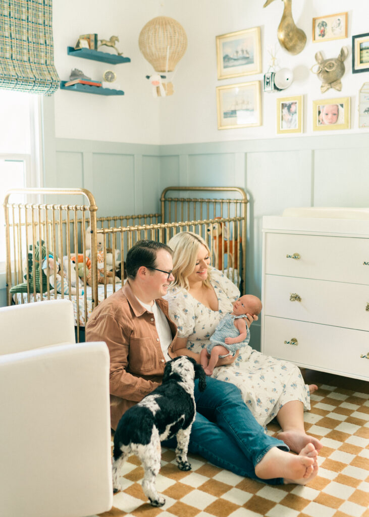 Parents holding their newborn in a bright, airy Holladay, Utah home session. Captured by Iris Graciela Photography.
