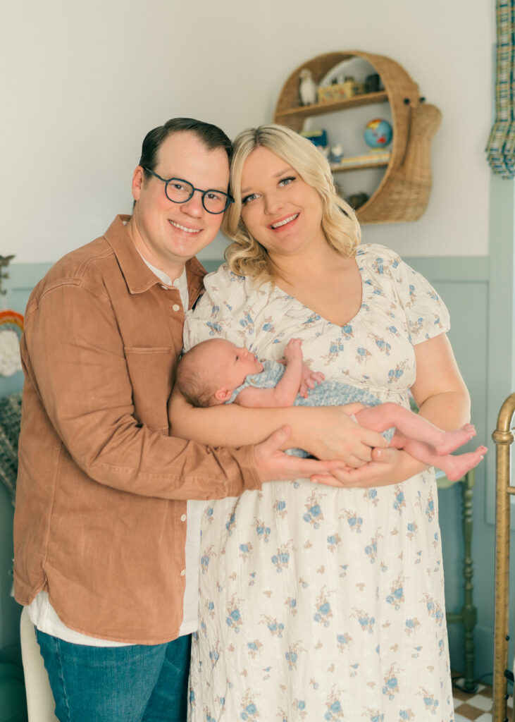 Parents holding their newborn in a bright, airy Holladay, Utah home session.